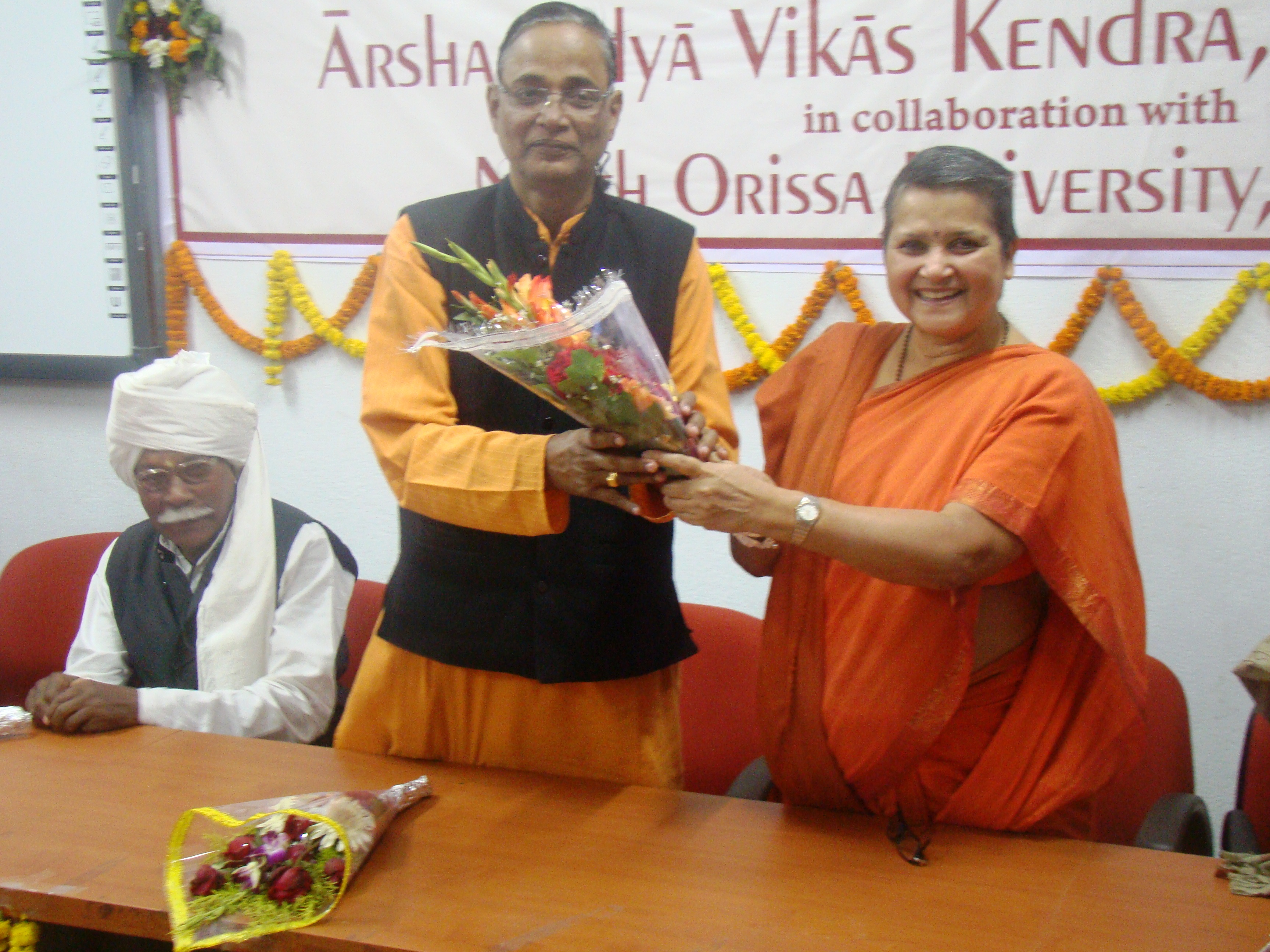 Swamini presenting a bouquest to Prof. Prafulla.K. Mishra, VC, NOU